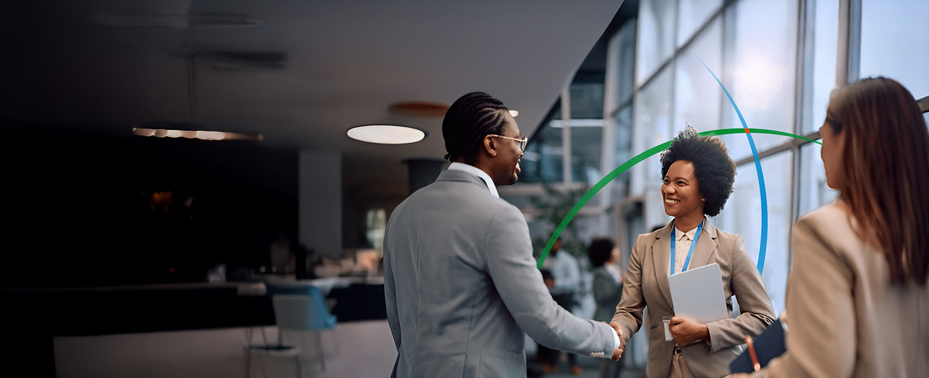 banner showing two professionals shaking hands while standing in a modern workspace