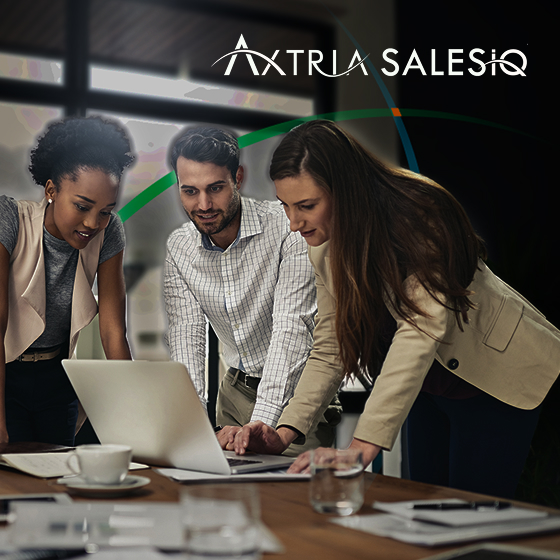 a team of business professionals having a discussion while huddled around a laptop placed on a wooden table