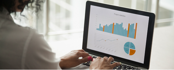 a business professional using a laptop to interact with an analytics dashboard