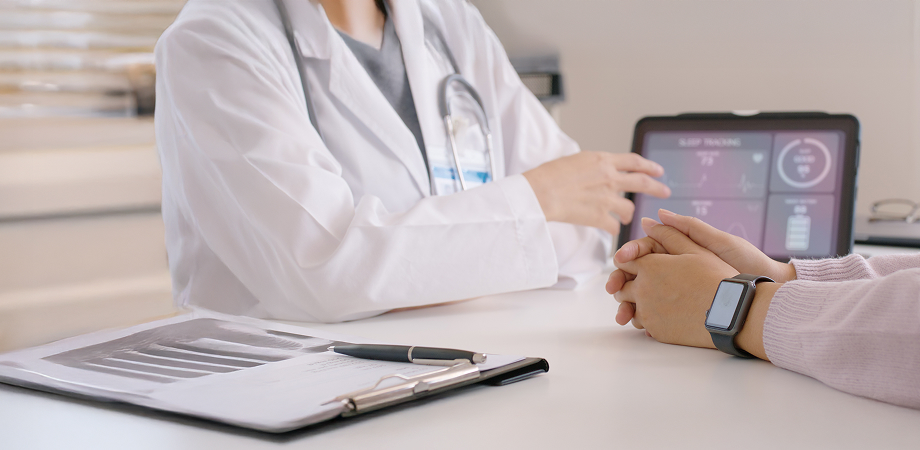 a healthcare professional pointing at a dashboard displayed on a tablet screen
