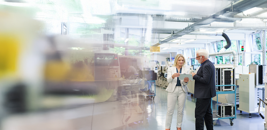 a man and a woman having a discussion in a medical lab while looking at a tablet screen