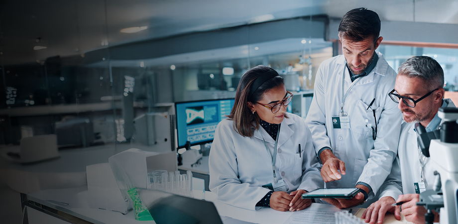 a team of medical professionals having a discussion while looking at a tablet screen